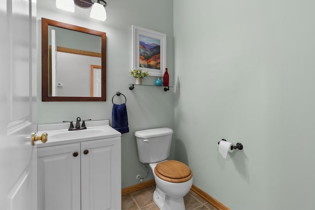 half bath featuring vanity, toilet, baseboards, and tile patterned flooring