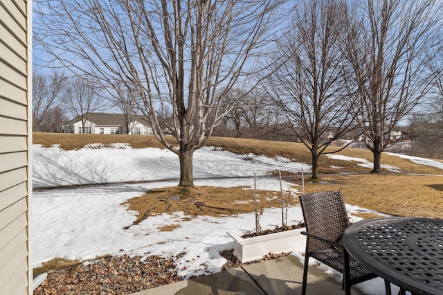 snowy yard featuring a patio area