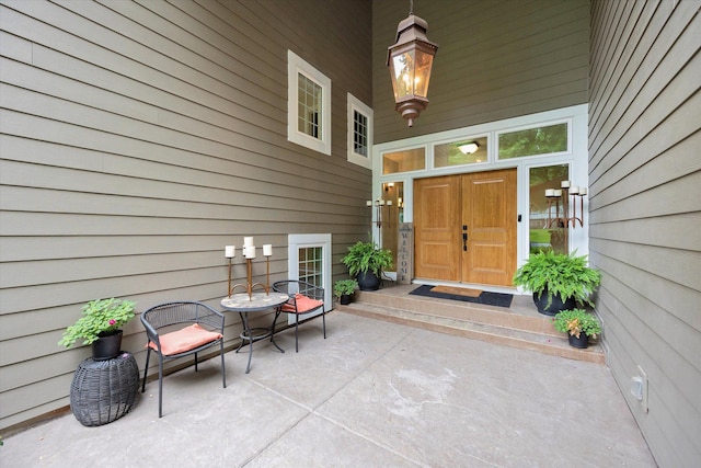 view of exterior entry with a patio area