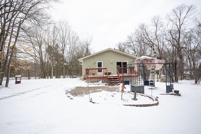 snow covered house with a wooden deck