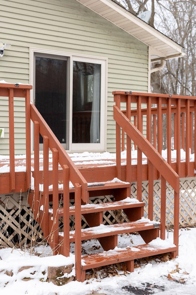 snow covered property entrance featuring a deck