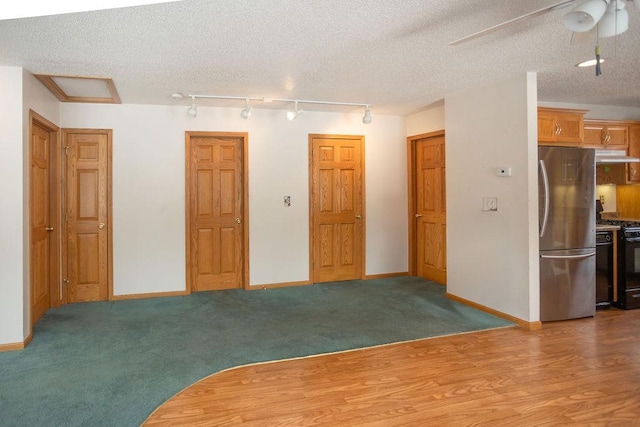 spare room with carpet floors, a textured ceiling, and baseboards