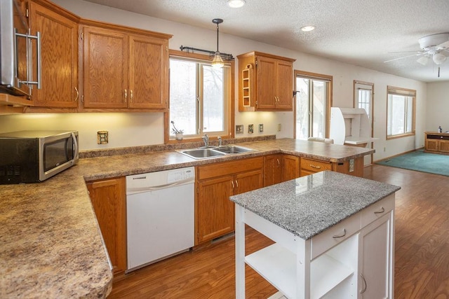 kitchen with open shelves, stainless steel microwave, a sink, dishwasher, and a peninsula