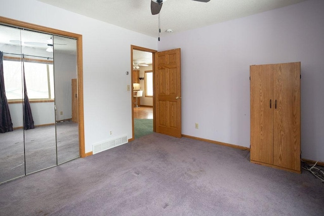 unfurnished bedroom with carpet floors, baseboards, visible vents, and a closet