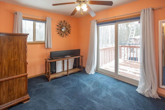 living area featuring carpet, a ceiling fan, and baseboards