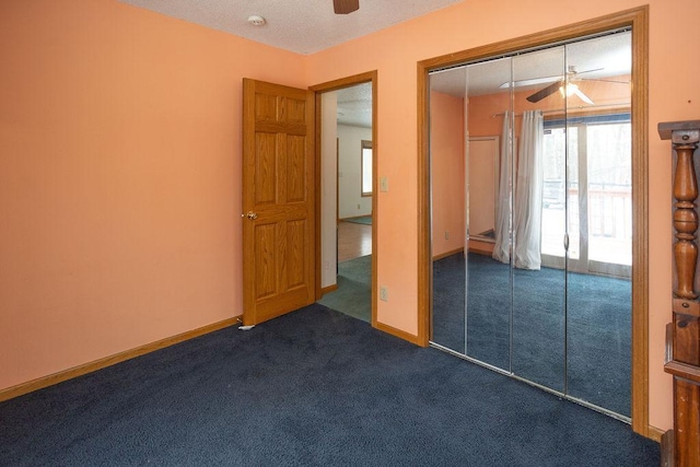 unfurnished bedroom with baseboards, a ceiling fan, dark colored carpet, and a closet