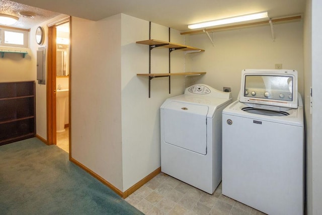 washroom featuring laundry area, electric panel, baseboards, and washing machine and clothes dryer