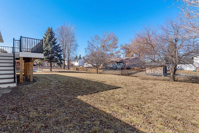 view of yard with stairway, fence, and a deck