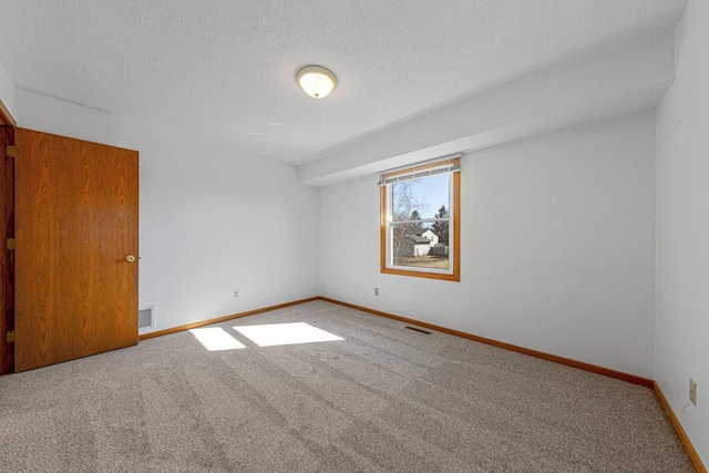 unfurnished bedroom featuring baseboards, visible vents, a textured ceiling, and carpet flooring