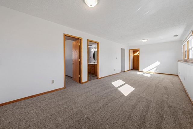 empty room with light carpet, visible vents, baseboards, and a textured ceiling