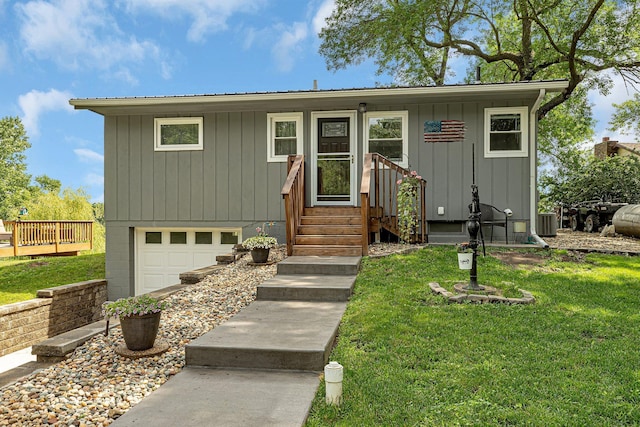 view of front facade featuring a garage, central AC unit, and a front yard