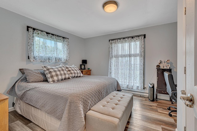 bedroom with baseboards and wood finished floors