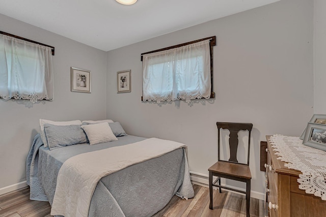 bedroom featuring baseboards and wood finished floors