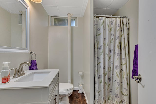 full bathroom with vanity, wood finished floors, a paneled ceiling, curtained shower, and toilet