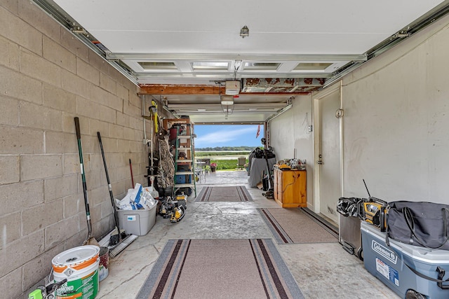 garage featuring concrete block wall and a garage door opener