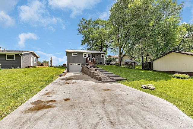 view of front of home with a garage, concrete driveway, and a front lawn