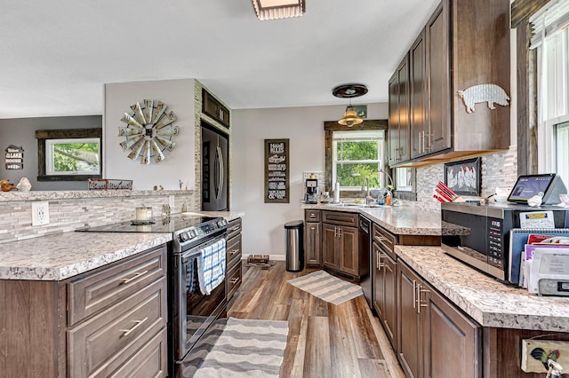 kitchen with decorative backsplash, appliances with stainless steel finishes, light countertops, and wood finished floors