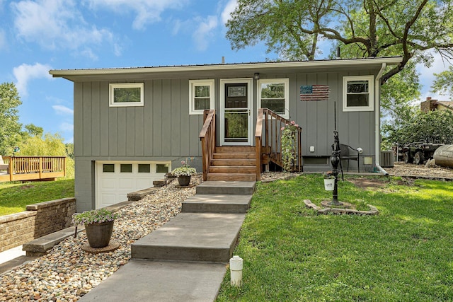view of front of property featuring central AC, board and batten siding, a front yard, an attached garage, and metal roof
