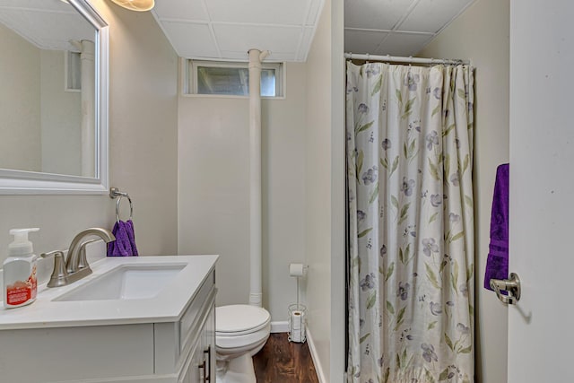 full bath featuring curtained shower, toilet, wood finished floors, vanity, and a paneled ceiling