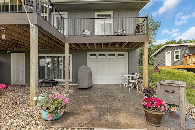 rear view of house featuring an attached garage, concrete driveway, a balcony, and board and batten siding