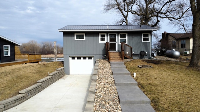 view of front of home with a garage, metal roof, and concrete driveway