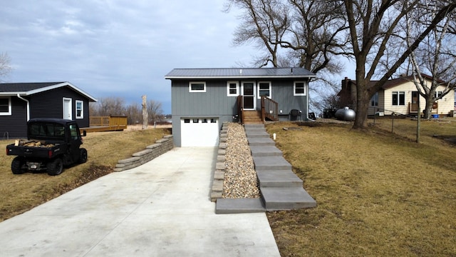 view of front facade with metal roof, concrete driveway, and an attached garage