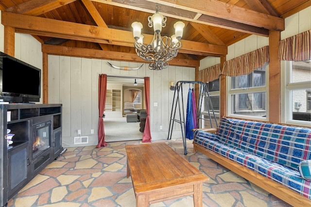 living room featuring wooden walls, visible vents, lofted ceiling with beams, wood ceiling, and a chandelier