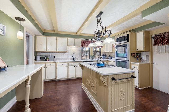 kitchen with light countertops, appliances with stainless steel finishes, dark wood finished floors, and decorative backsplash