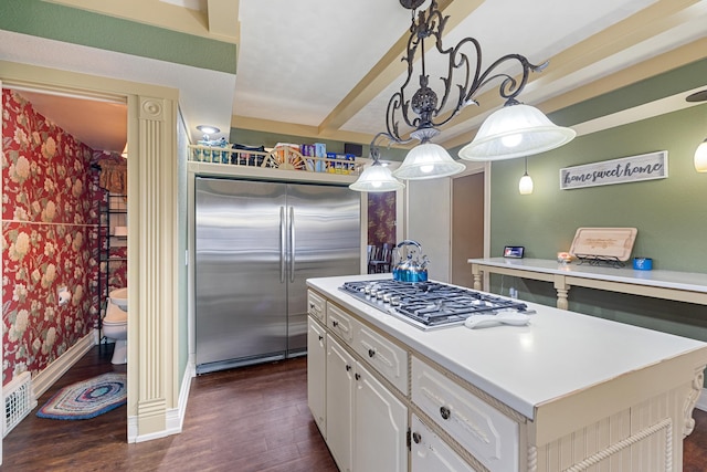 kitchen featuring white cabinets, appliances with stainless steel finishes, a center island, dark wood-style floors, and wallpapered walls