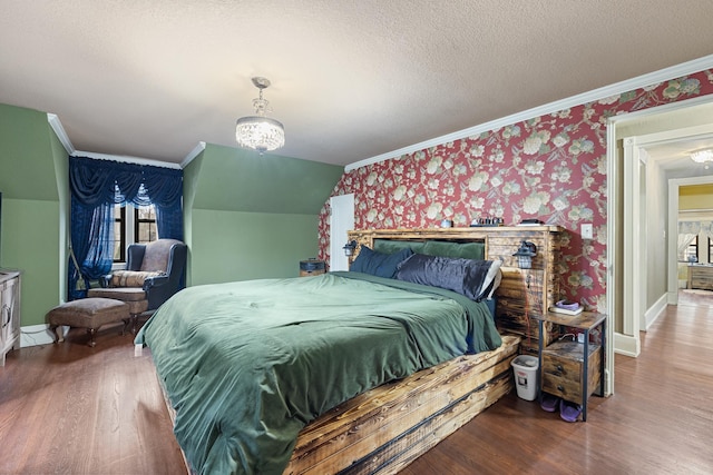 bedroom featuring a textured ceiling, wood finished floors, and wallpapered walls