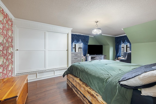 bedroom featuring a textured ceiling, crown molding, wood finished floors, and wallpapered walls