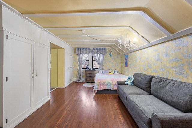 bedroom with a chandelier, wood finished floors, lofted ceiling, and wallpapered walls