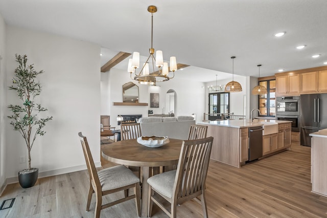 dining room with recessed lighting, visible vents, light wood-style floors, a glass covered fireplace, and baseboards