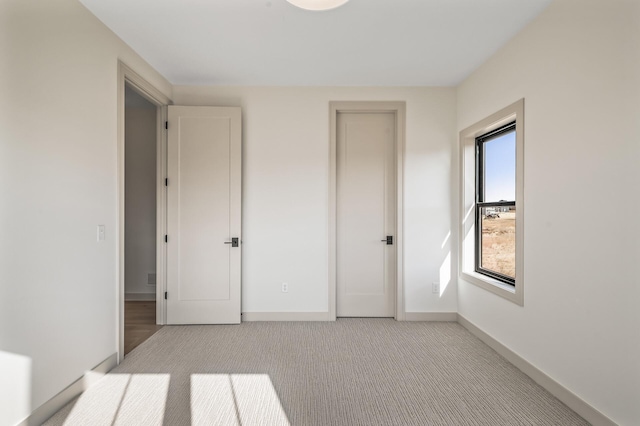 unfurnished bedroom with carpet floors and baseboards