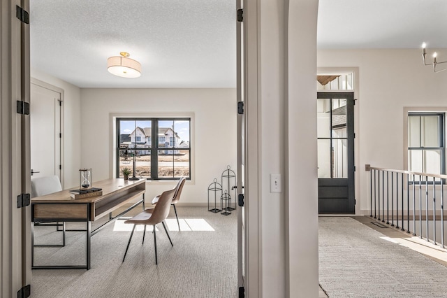 office space with a textured ceiling, carpet floors, and baseboards