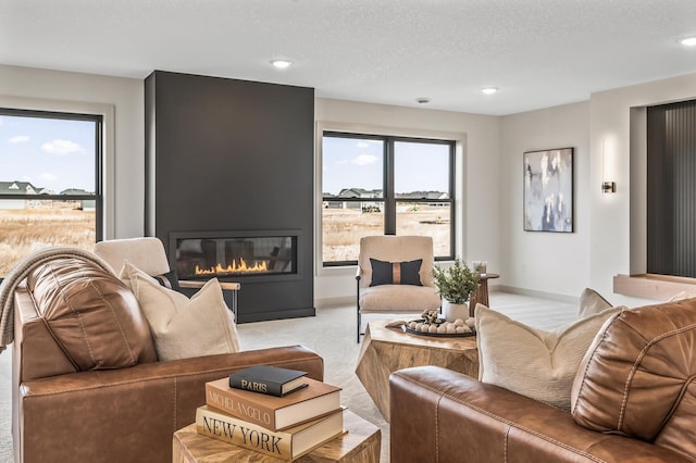 living area featuring a large fireplace, baseboards, a textured ceiling, carpet floors, and recessed lighting