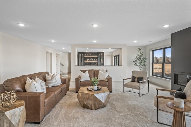 carpeted living area featuring recessed lighting, a textured ceiling, and baseboards