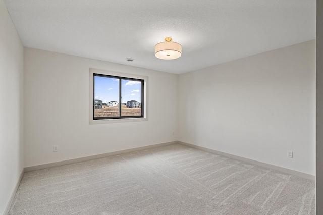 empty room with baseboards and light colored carpet