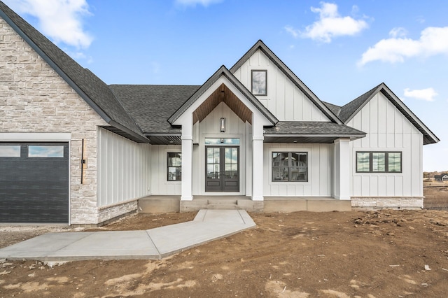 exterior space with stone siding, french doors, board and batten siding, and roof with shingles