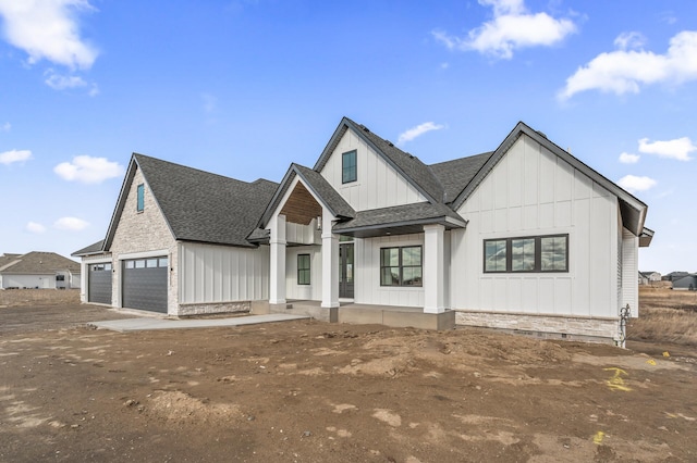 modern farmhouse with a shingled roof and board and batten siding