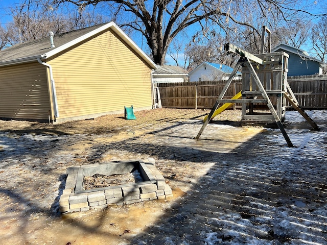 view of jungle gym with a fire pit and fence