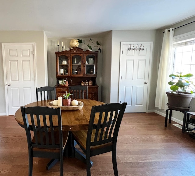 dining space with wood finished floors and baseboards