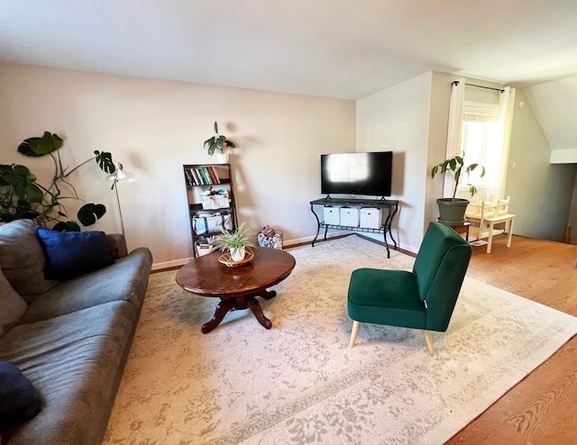 living area with lofted ceiling and baseboards