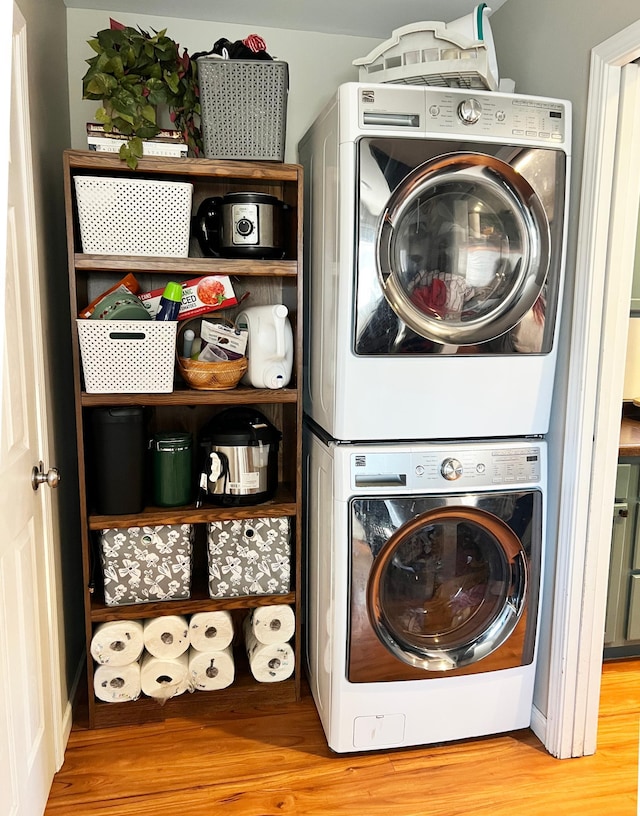 laundry area with wood finished floors and stacked washer and clothes dryer