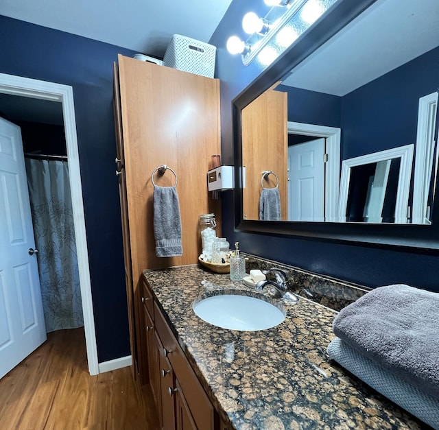 bathroom with vanity, baseboards, and wood finished floors