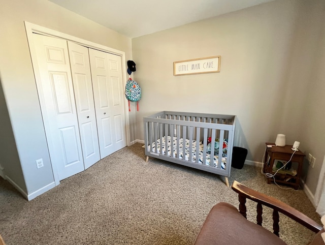 bedroom with carpet, a closet, a crib, and baseboards