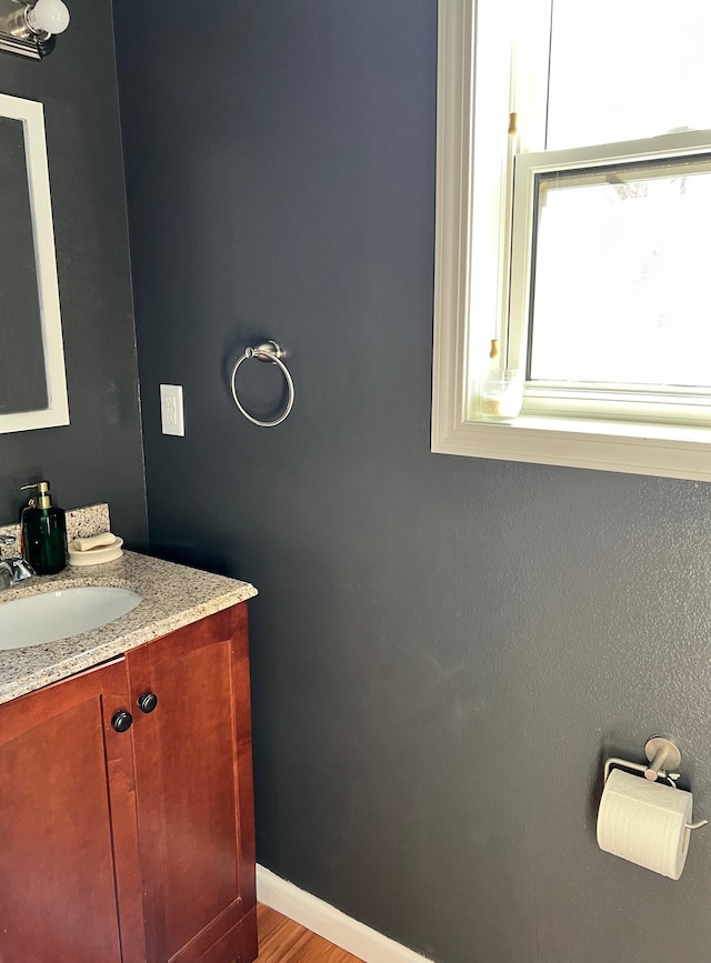 bathroom featuring wood finished floors, vanity, and baseboards