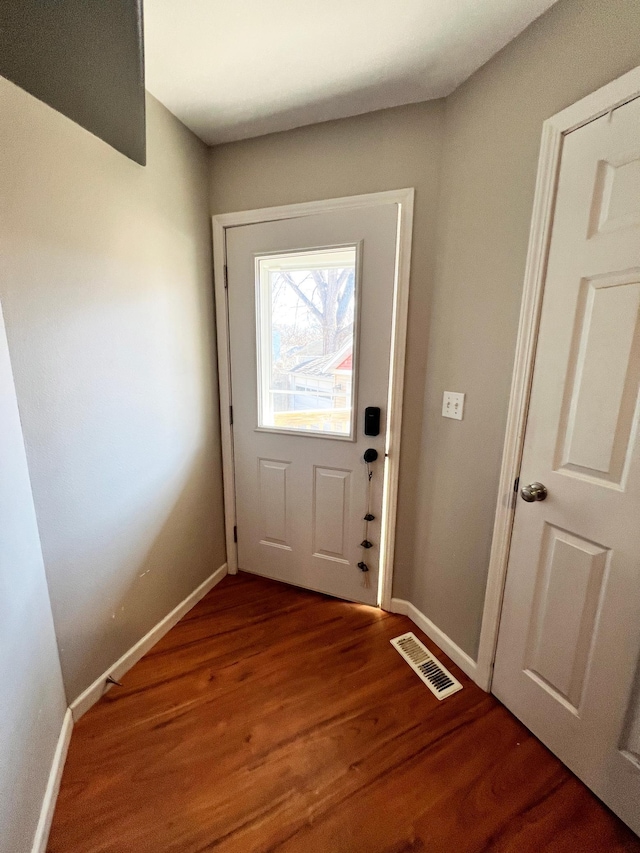 doorway to outside with wood finished floors, visible vents, and baseboards