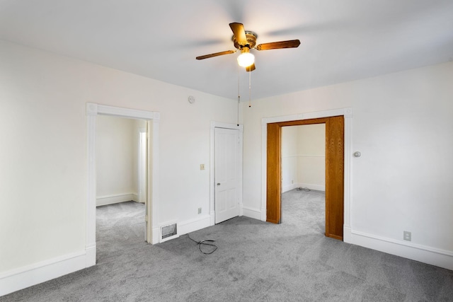 unfurnished room with ceiling fan, carpet flooring, visible vents, and baseboards