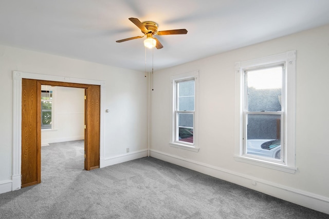 carpeted spare room featuring a ceiling fan